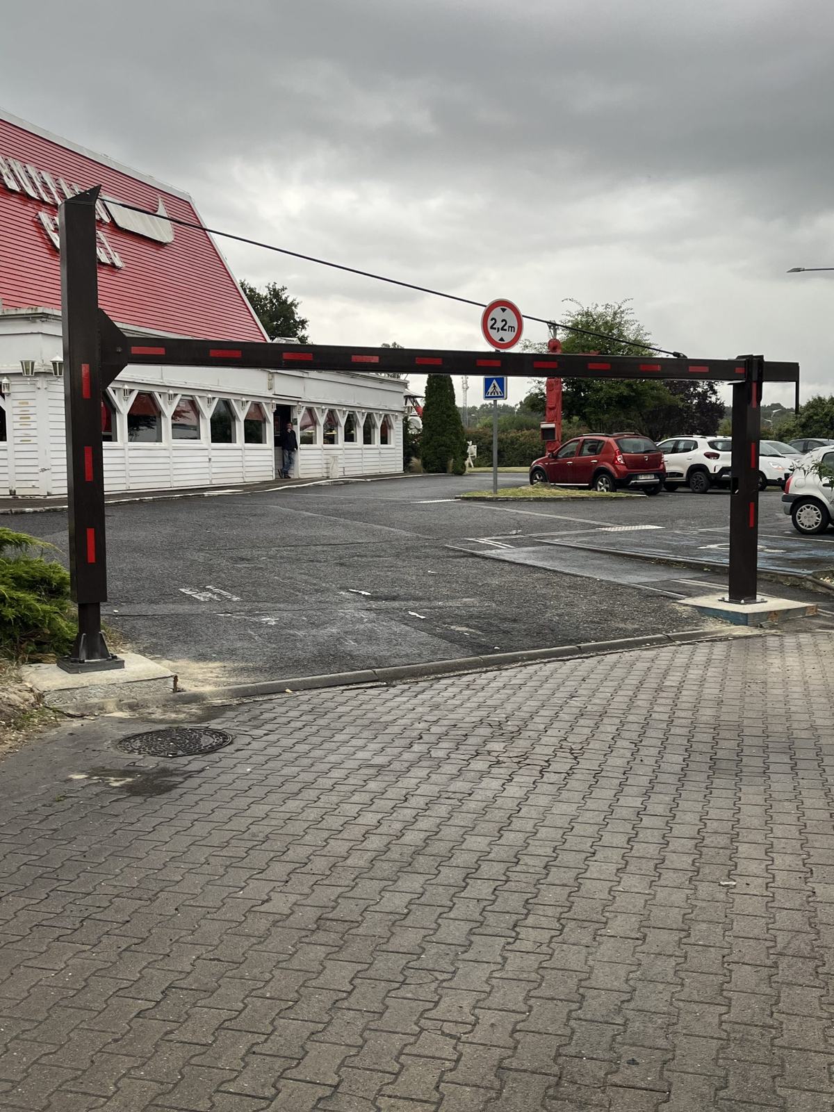 Poutre pivotante manuelle noire et rouge avec limitation de hauteur devant un Buffalo Grill