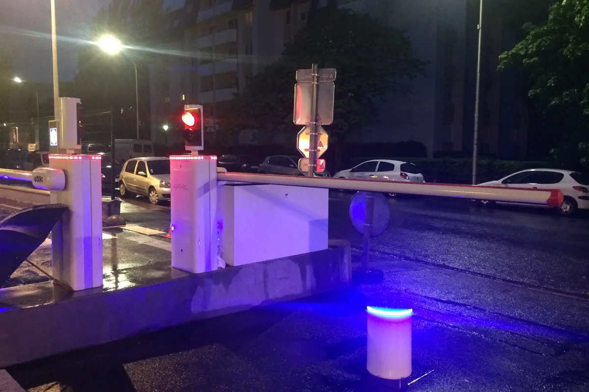 Barrière levante automatique et bornes lumineuses sécurisant un accès urbain de nuit, JCD Services