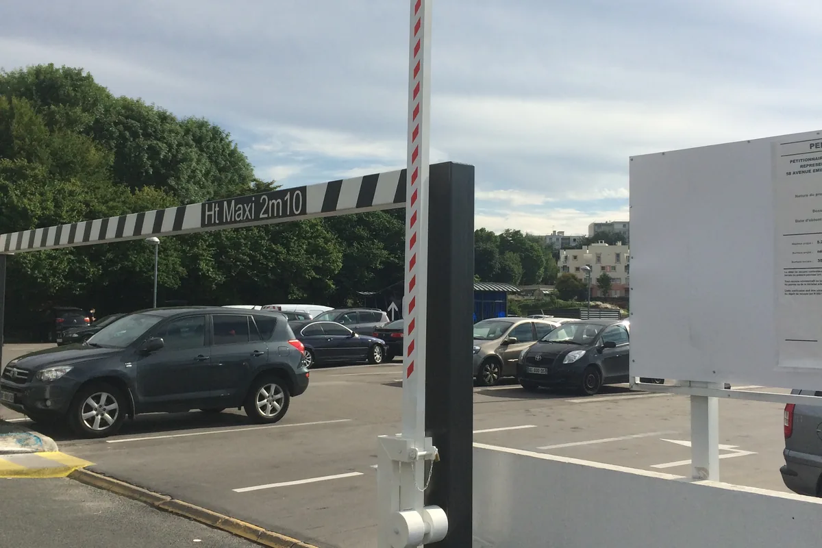Barrière levante manuelle en position ouverte sur un accès de parking à hauteur limitée, JCD Services