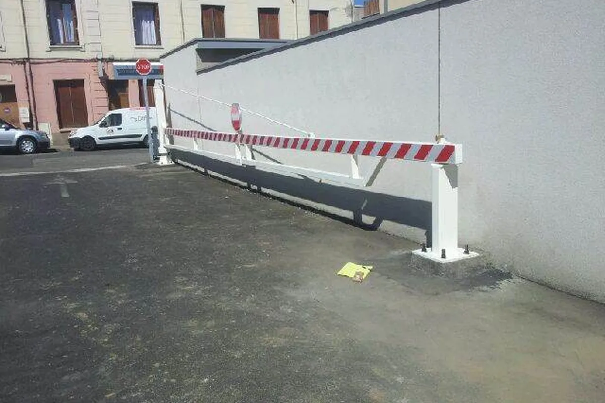 Barrière pivotante manuelle fermant la rampe d'un parking résidentiel, JCD Services