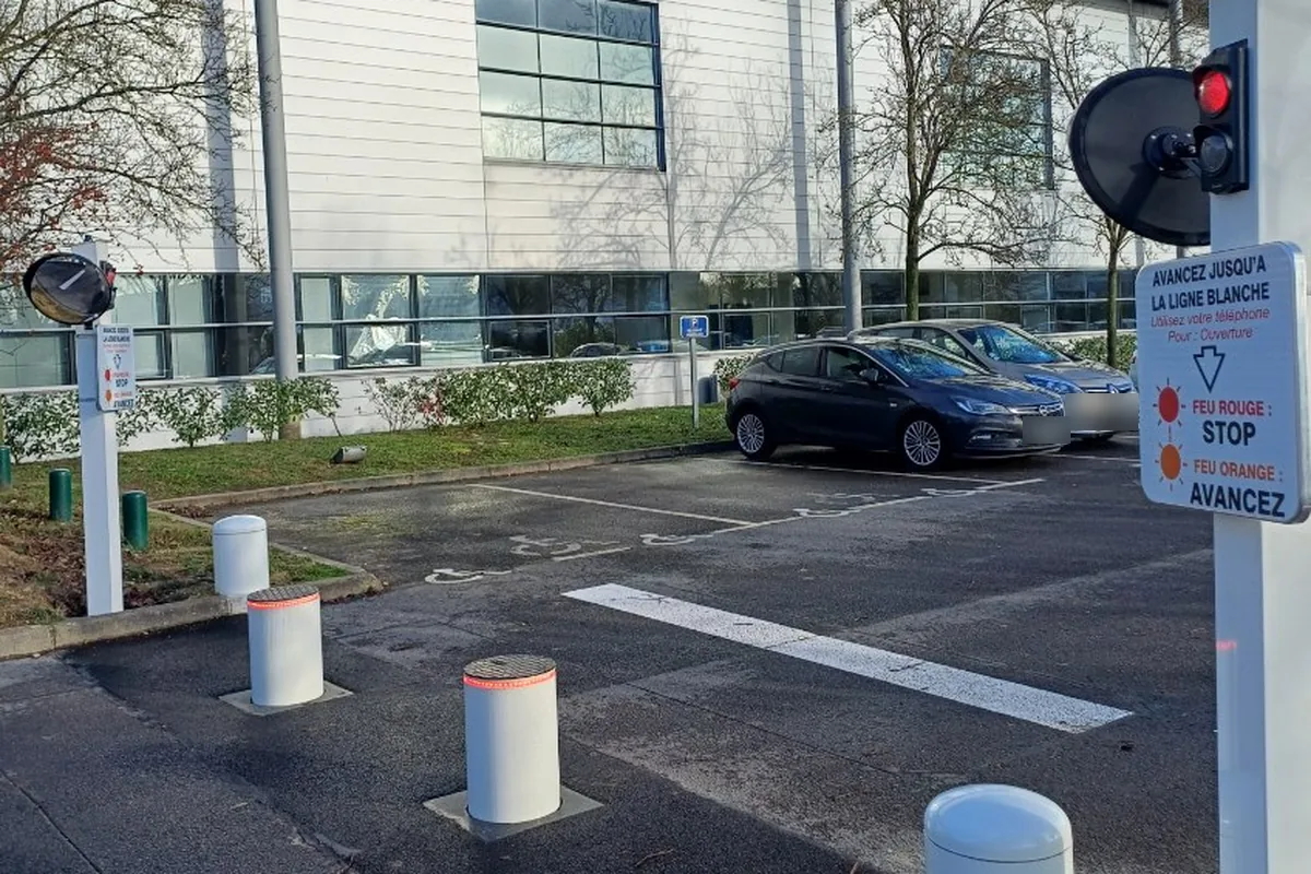 Bornes escamotables et feu tricolore à l'entrée d'un parking d'entreprise, JCD Services