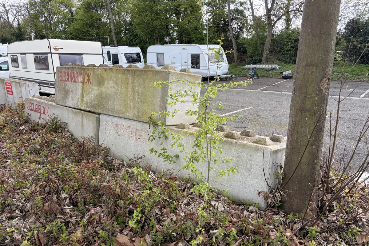 Caravanes installées derrière des blocs béton sur le parking d'une zone d'activité à Osny (95), constat lors de l'audit JCD Services