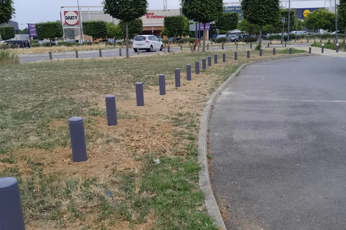 Alignement de bornes fixes acier le long d'un parking de zone commerciale, JCD Services